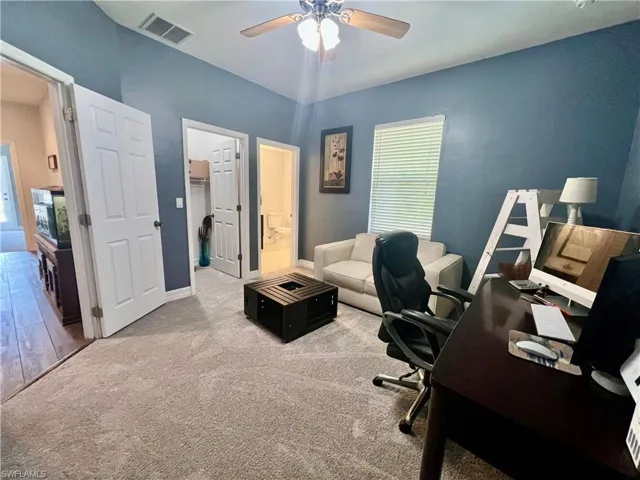 Guest bedroom featuring baseboards and a private ensuite bathroom.