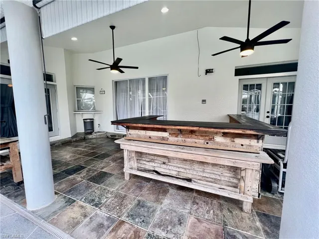 Covered lanai with slate tile and dry bar.
