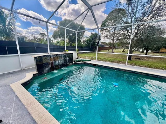 In ground pool with waterfall and a spacious patio