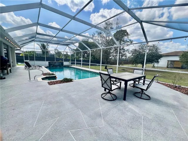 In ground pool with waterfall and a spacious patio