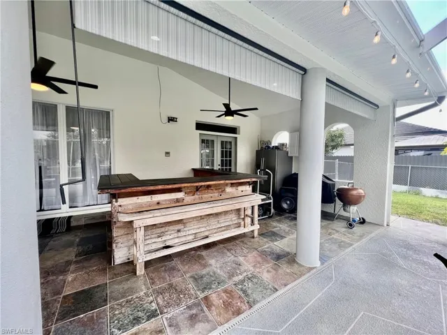 Covered lanai with slate tile and dry bar.
