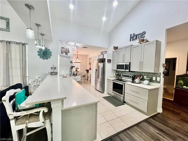 Kitchen with QUARTZ tops, breakfast bar and stainless steel appliances.