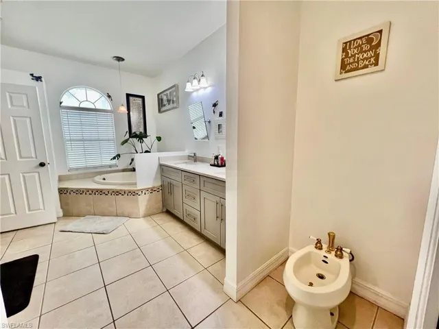 Full bathroom with a garden tub, separate shower, tile patterned flooring, a bidet, and vanity