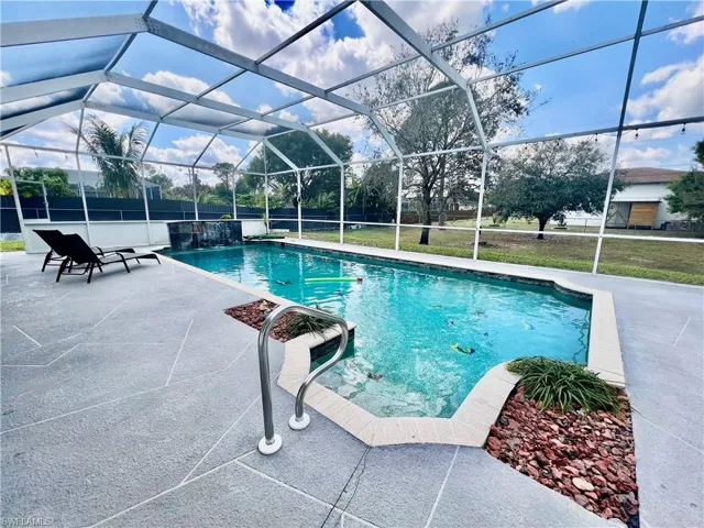 In ground pool with waterfall and a spacious patio