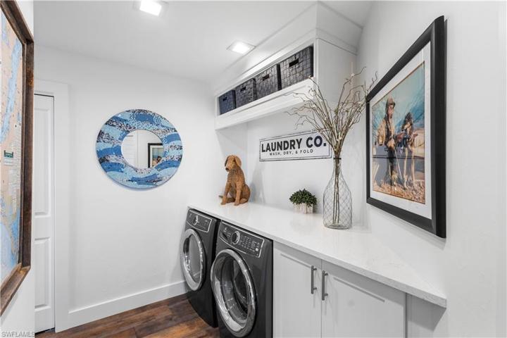 Nicely sized laundry room with storage spaces.