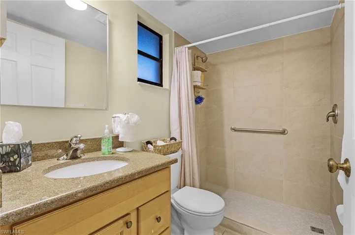 Bathroom with a shower with shower curtain, vanity, and toilet