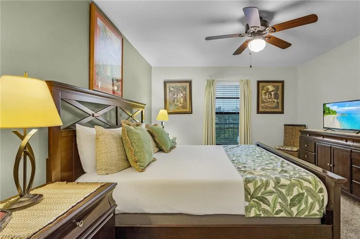 Carpeted bedroom featuring ceiling fan