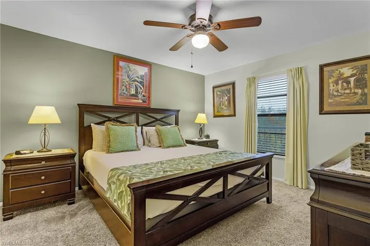 Bedroom with ceiling fan and light colored carpet