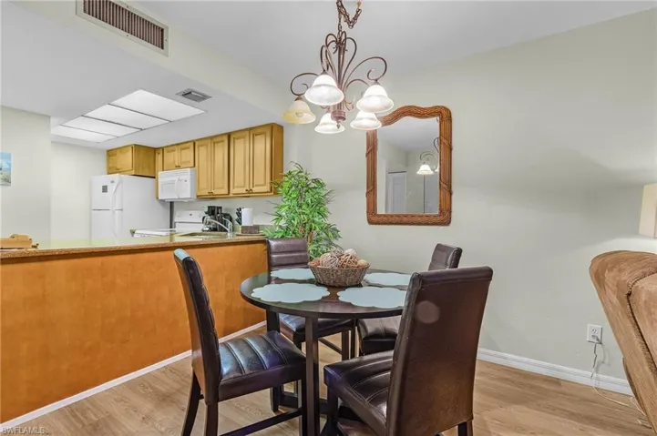 Dining area with a chandelier, light wood-type flooring, and sink