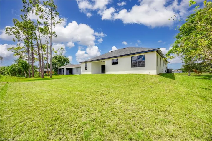 Back of property with a lawn