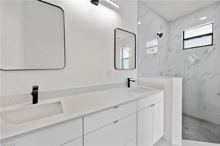 Bathroom with vanity and tiled shower
