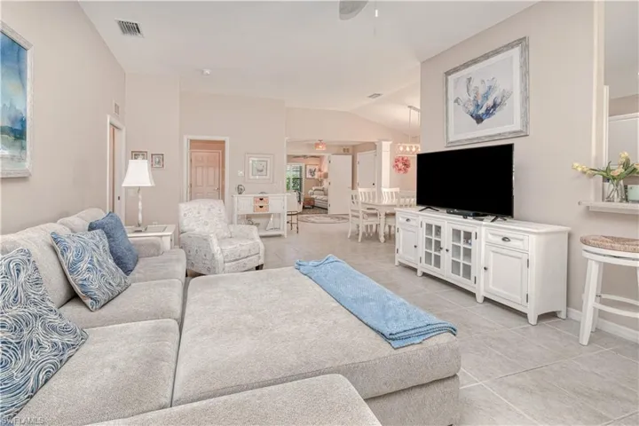 Tiled living room featuring vaulted ceiling