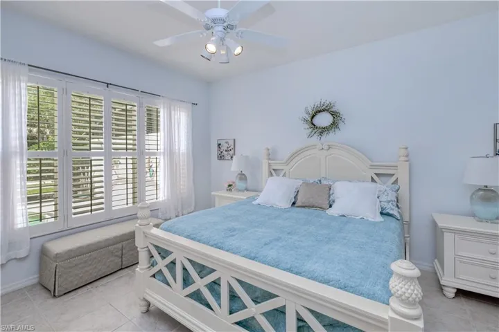 Tiled bedroom featuring ceiling fan