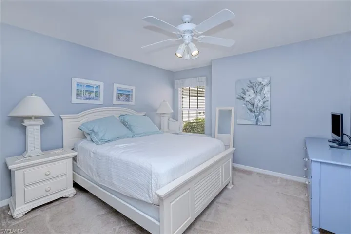 Carpeted bedroom featuring ceiling fan