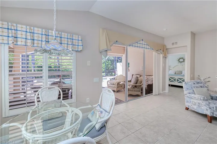 Dining area with vaulted ceiling and light tile flooring