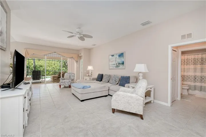 Living room with ceiling fan and light tile floors