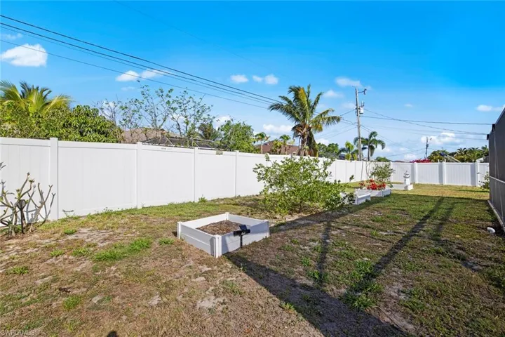 View of yard featuring a fenced backyard and a vegetable garden
