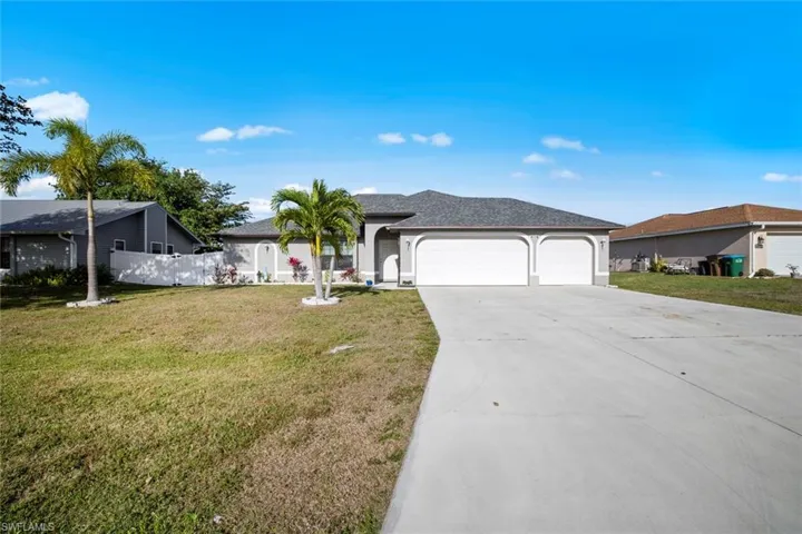 Single story home featuring a garage, concrete driveway, fence, stucco siding, and a front lawn