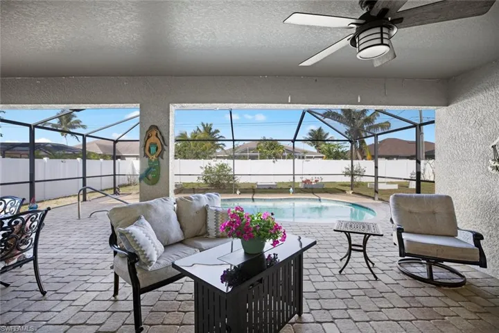 View of patio featuring an outdoor living space, a fenced backyard, and glass enclosure