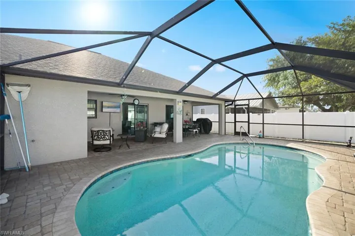 View of swimming pool featuring a lanai, a patio area, a fenced in pool, and fence