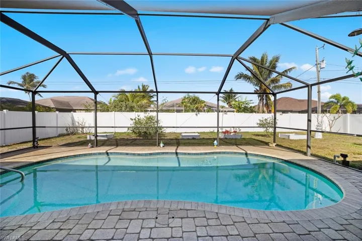View of pool featuring a fenced backyard, glass enclosure, a fenced in pool, and a patio