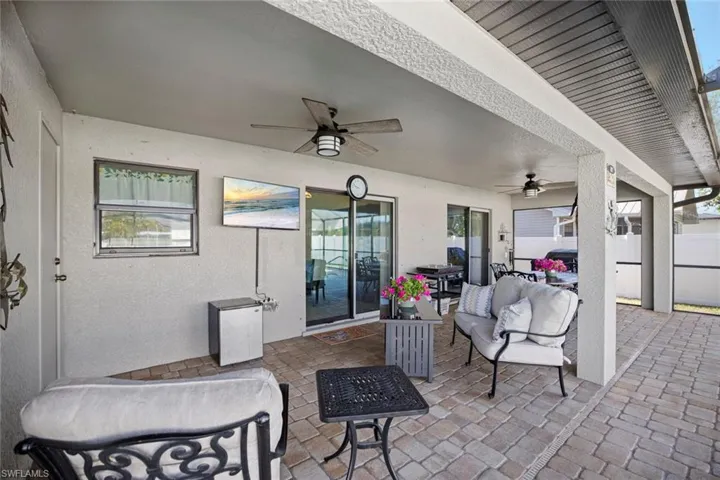 View of patio with a ceiling fan, an outdoor living space, and fence