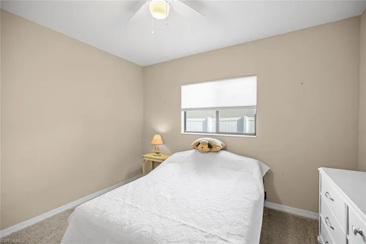 Carpeted bedroom featuring baseboards and a ceiling fan