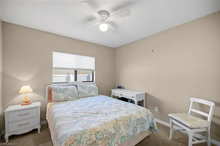 Bedroom featuring ceiling fan, baseboards, and carpet