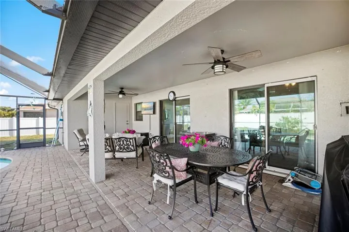 View of patio featuring ceiling fan, outdoor dining space, an outdoor hangout area, and a lanai