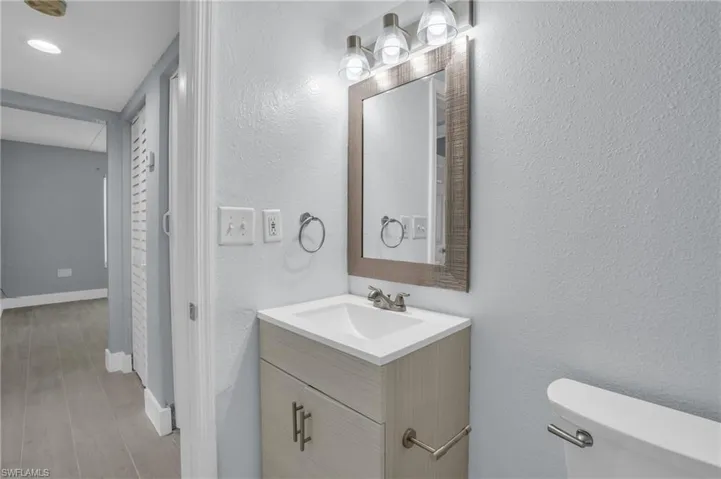 Bathroom featuring oversized vanity, hardwood / wood-style flooring, and toilet
