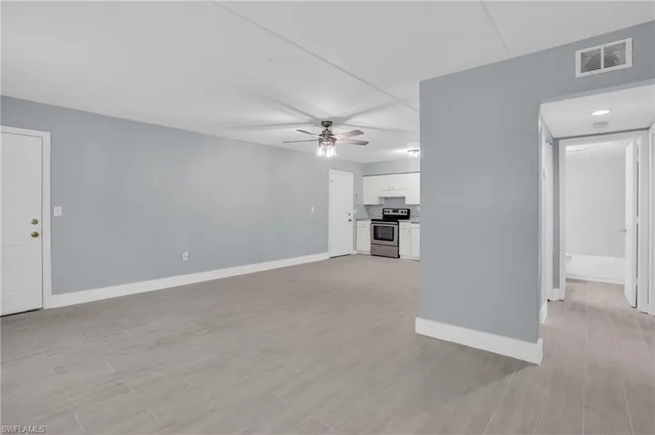 Unfurnished living room with ceiling fan and light hardwood / wood-style flooring