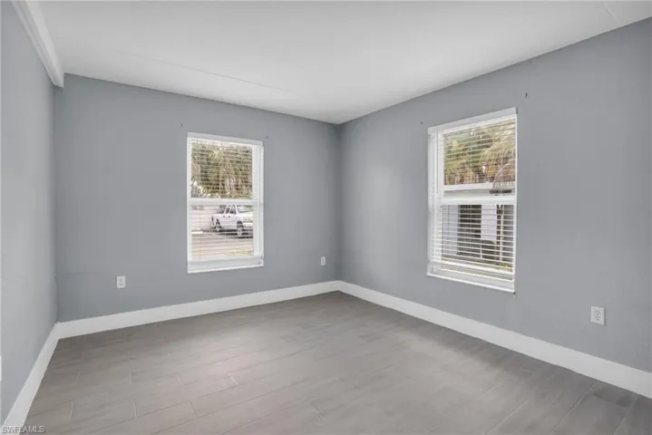 Unfurnished room featuring hardwood / wood-style flooring and a wealth of natural light