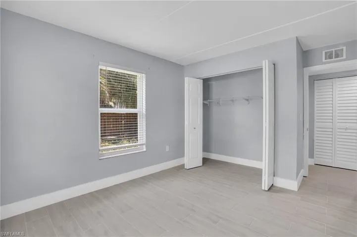 Unfurnished bedroom featuring a closet and multiple windows