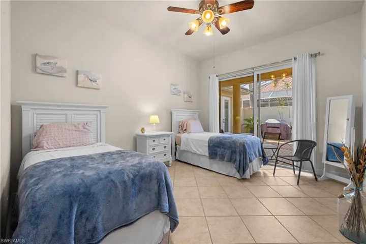 Guest Bedroom with access to courtyard, twin beds, tiled flooring.