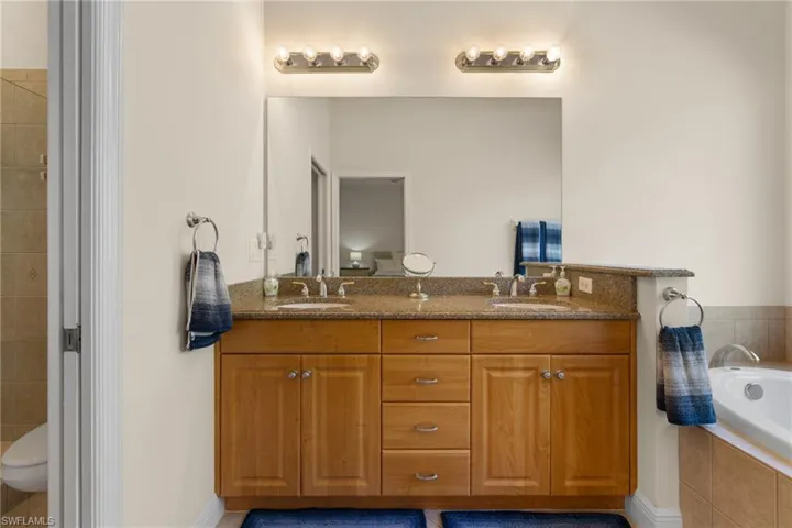 Primary Bathroom featuring dual sink vanity, soaking tub.