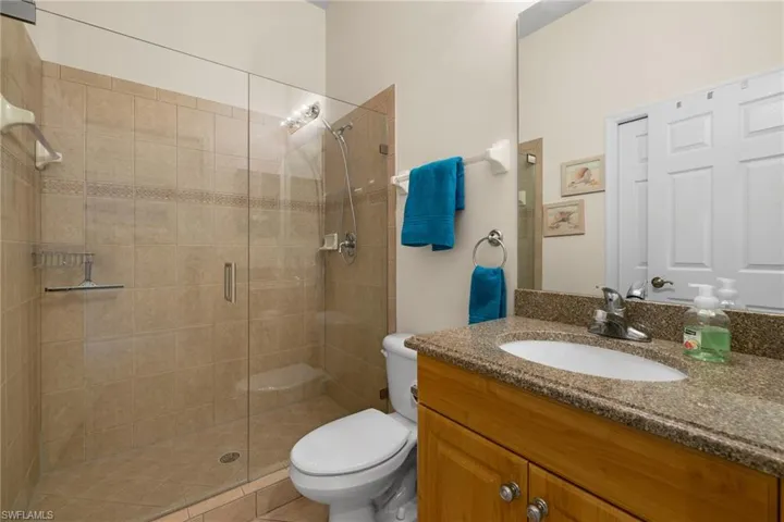 Guest Bathroom with granite vanity, a new walk-in glass in shower and toilet