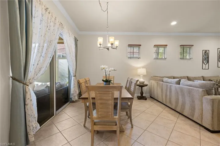 Tiled dining room with crown molding and an inviting look onto the courtyard.