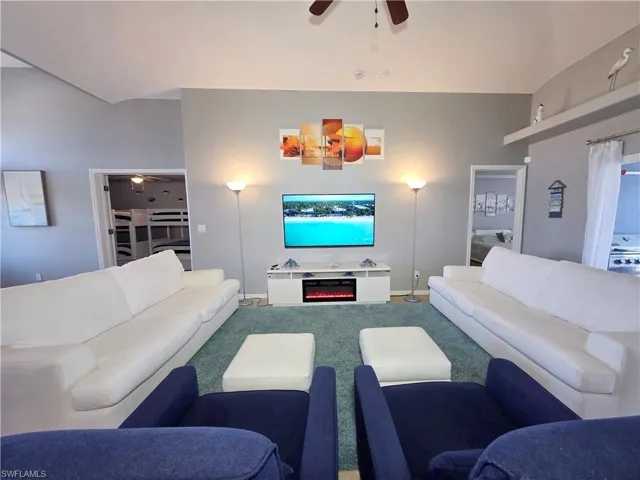 Living area with ceiling fan and carpet