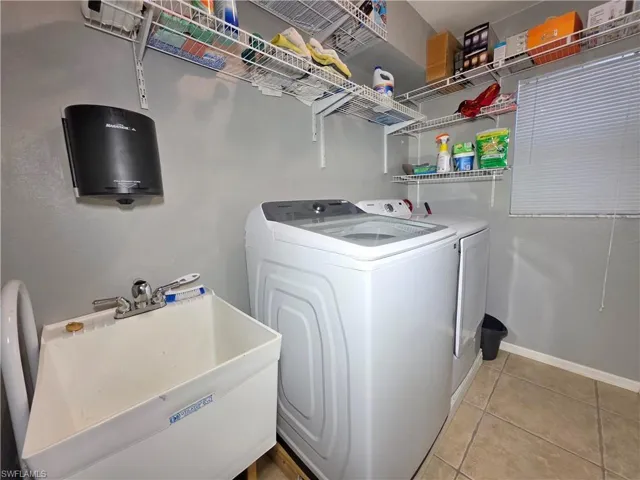 Washroom featuring washer and dryer and light tile patterned flooring