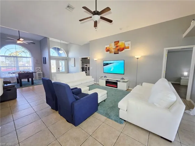 Living room with a ceiling fan and light tile patterned floors