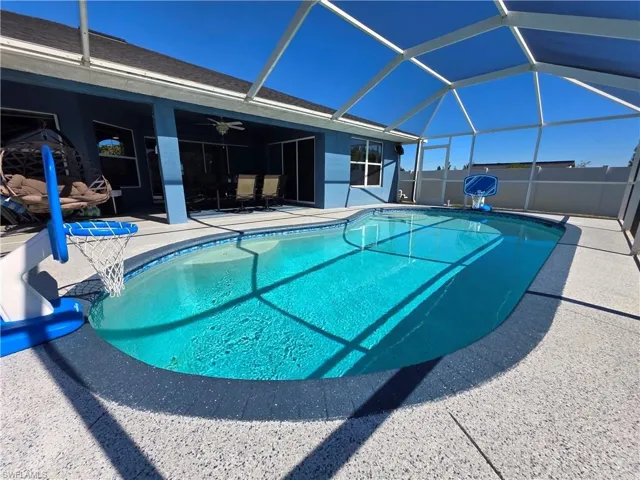 View of swimming pool with a sunroom, a patio area, and a lanai