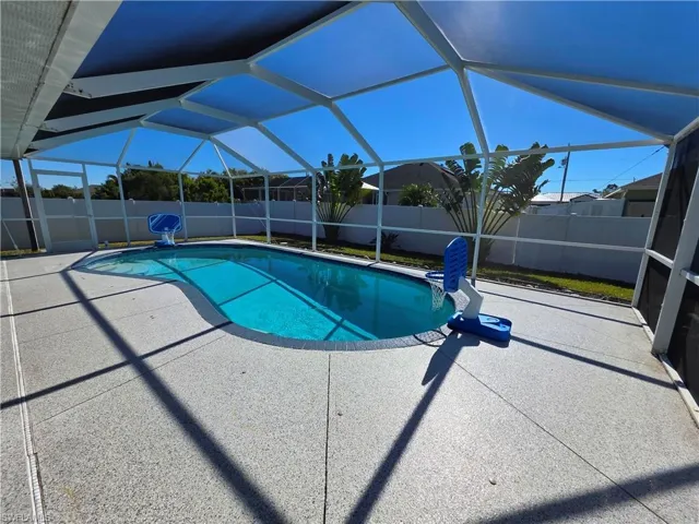 View of swimming pool featuring a sunroom, a fenced backyard, and a lanai