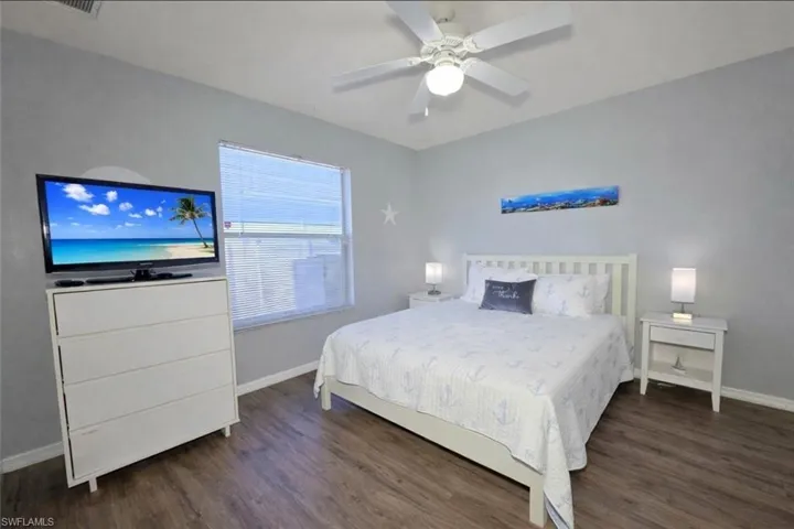 Bedroom with dark wood-style floors and a ceiling fan