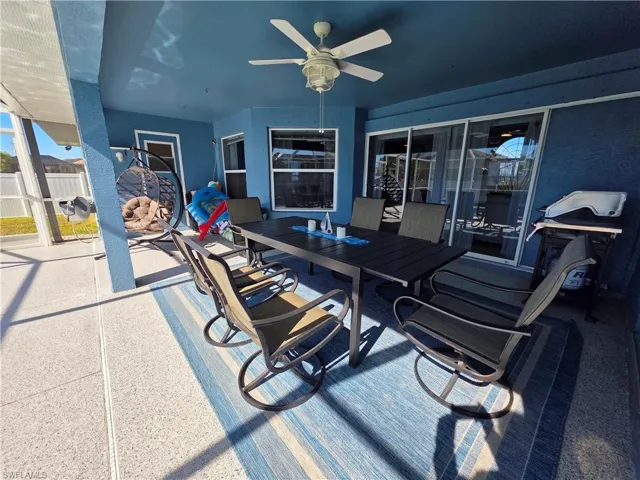 View of patio featuring outdoor dining area, a ceiling fan, and a grill