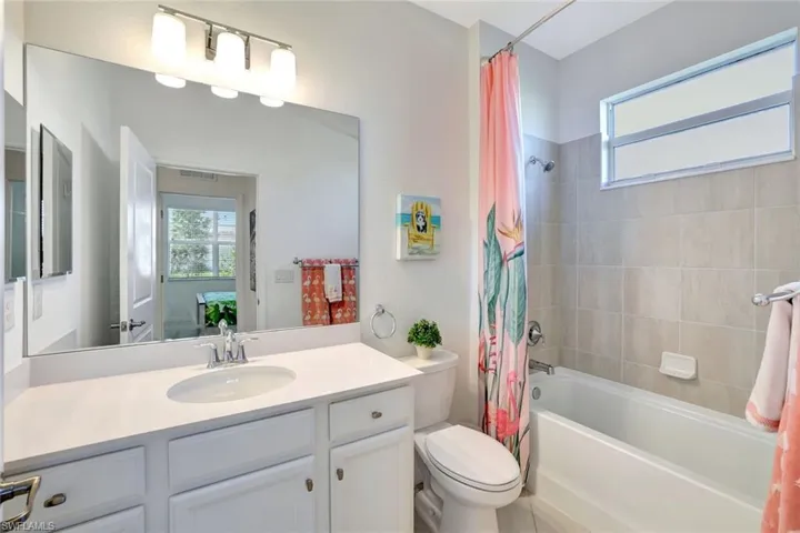 Full bathroom with shower / bath combo, vanity, visible vents, and toilet