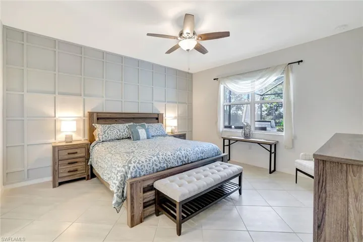 Bedroom with ceiling fan, baseboards, and light tile patterned flooring
