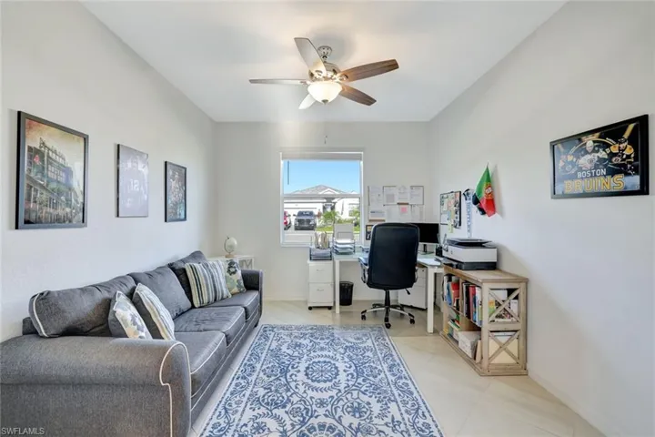Office space with baseboards, light tile patterned flooring, and ceiling fan