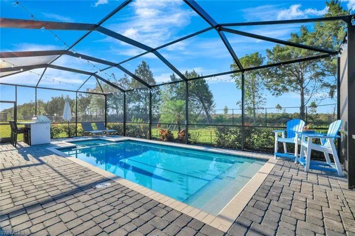 Outdoor pool featuring a patio area and glass enclosure