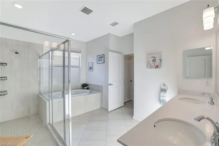 Full bathroom featuring a shower stall, tile patterned floors, visible vents, and a sink
