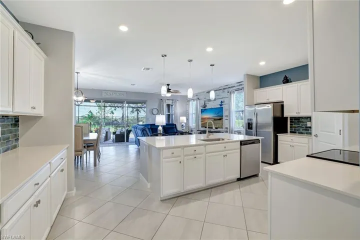 Kitchen featuring recessed lighting, a sink, stainless steel appliances, open floor plan, and decorative backsplash